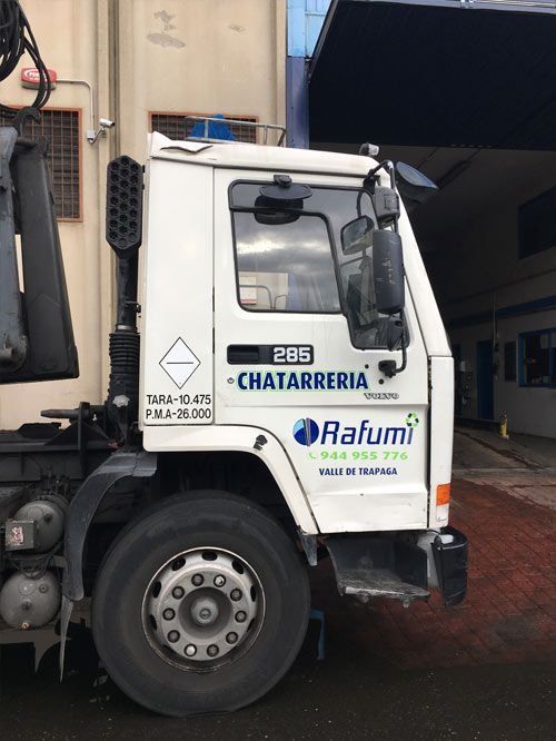 Camión blanco de CHARTARRIA/Rafumi estacionado junto a un muelle de carga de un almacén.