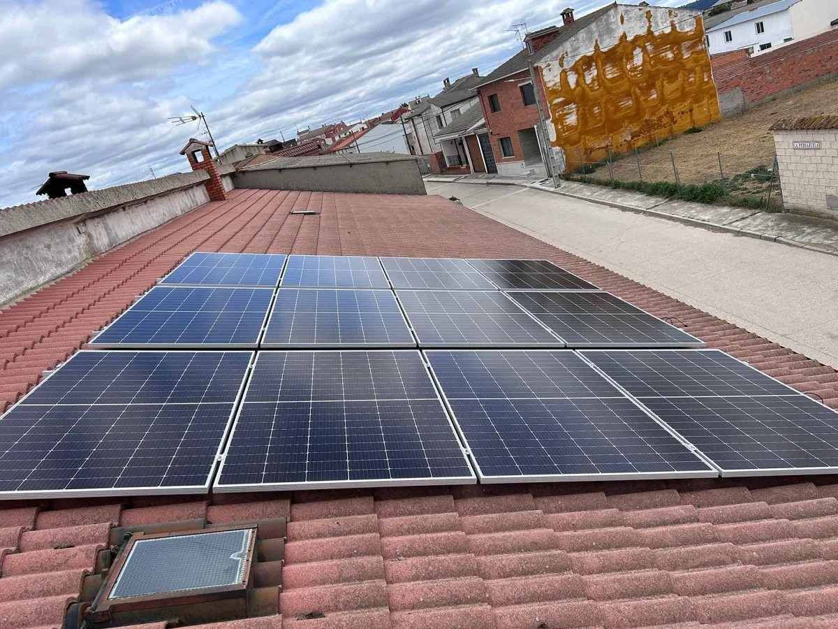Paneles solares instalados en un tejado bajo un cielo nublado.