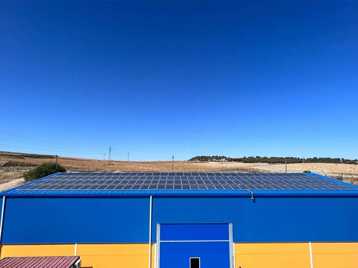 Edificio con tejado azul bajo un cielo despejado en un paisaje seco y abierto