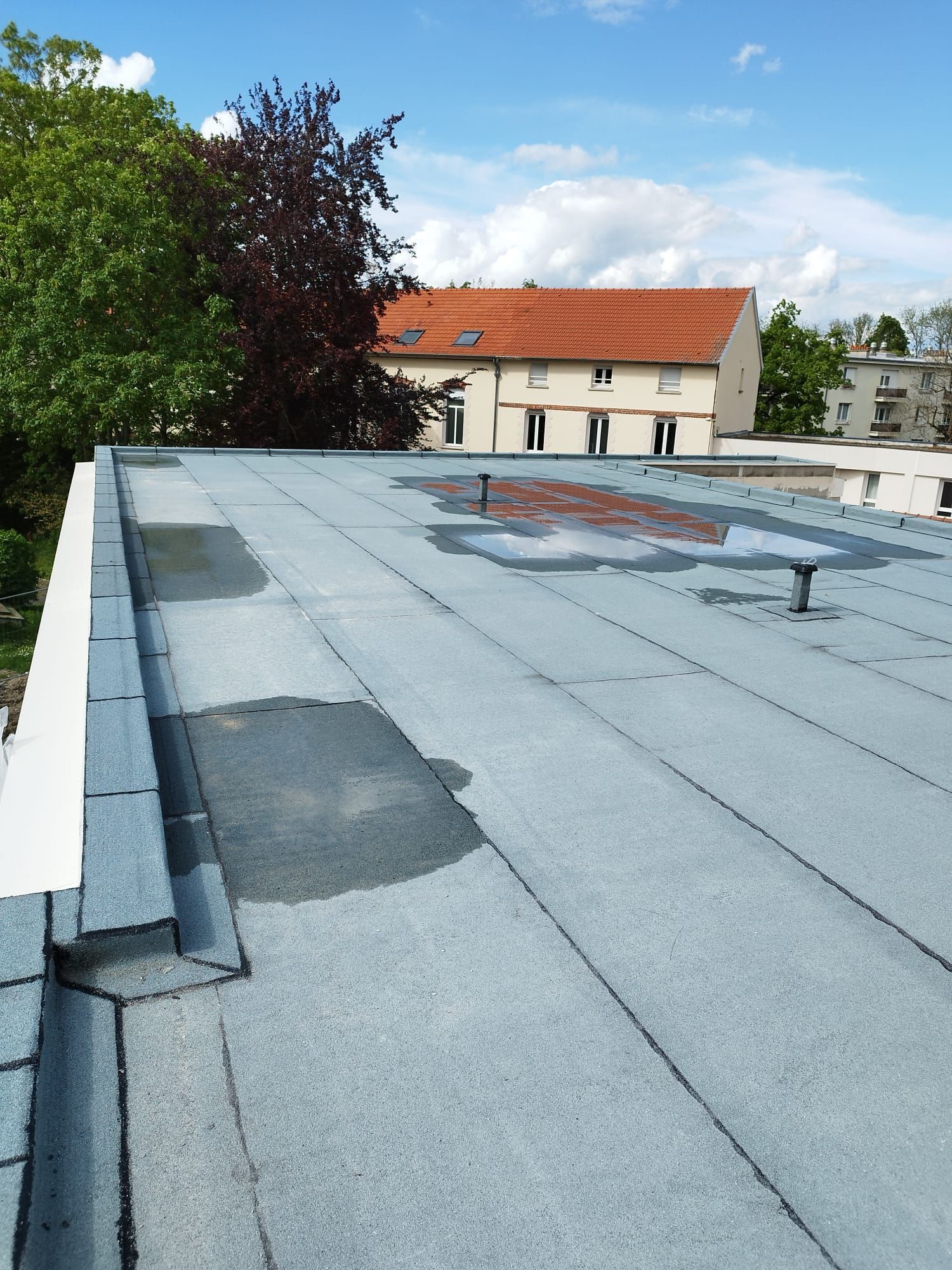 Toit plat en face d'une maison avec toit en tuile