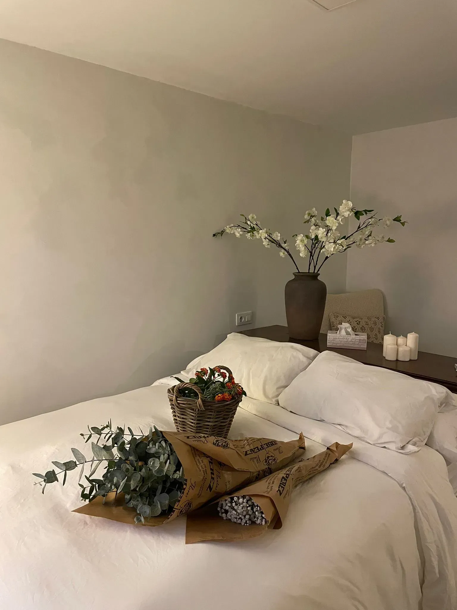 Planta en maceta color dorado sobre un pequeño taburete redondo con patas de madera.