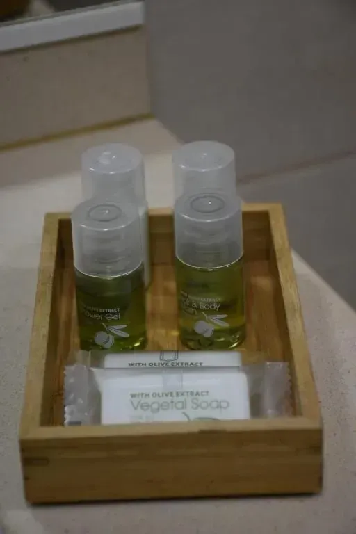 Bandeja de madera que contiene dos botellas de champú y una pastilla de jabón.