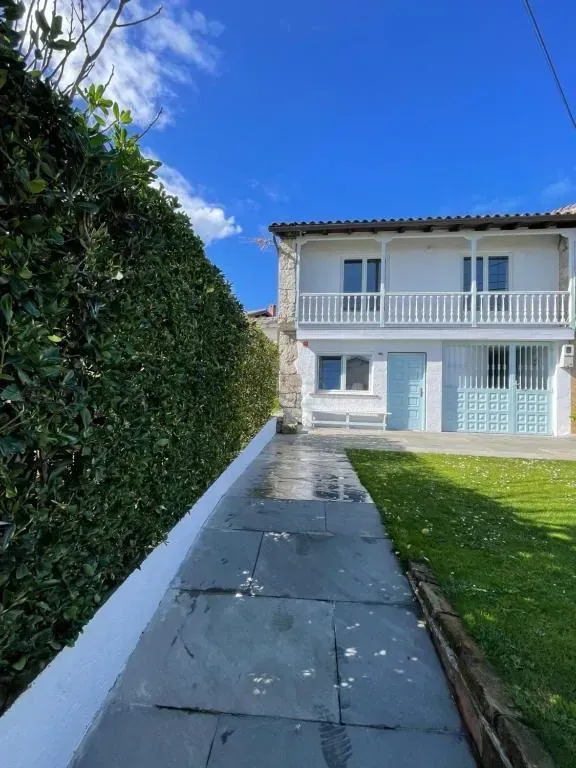 Sala de estar con pared de piedra, vigas de madera, mueble rojo y sofá azul.
