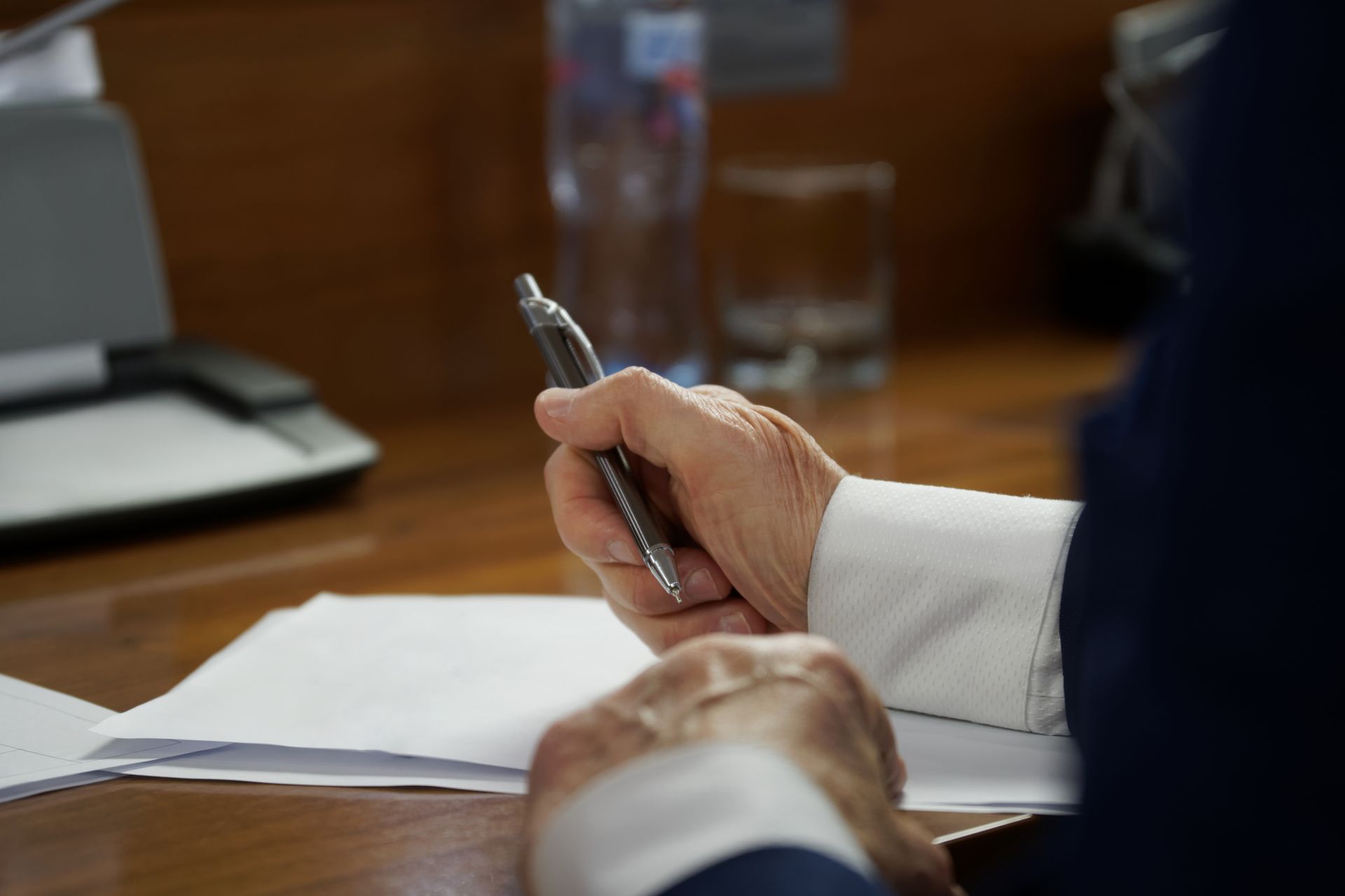 stylo dans la main d'un homme et feuille blanche.