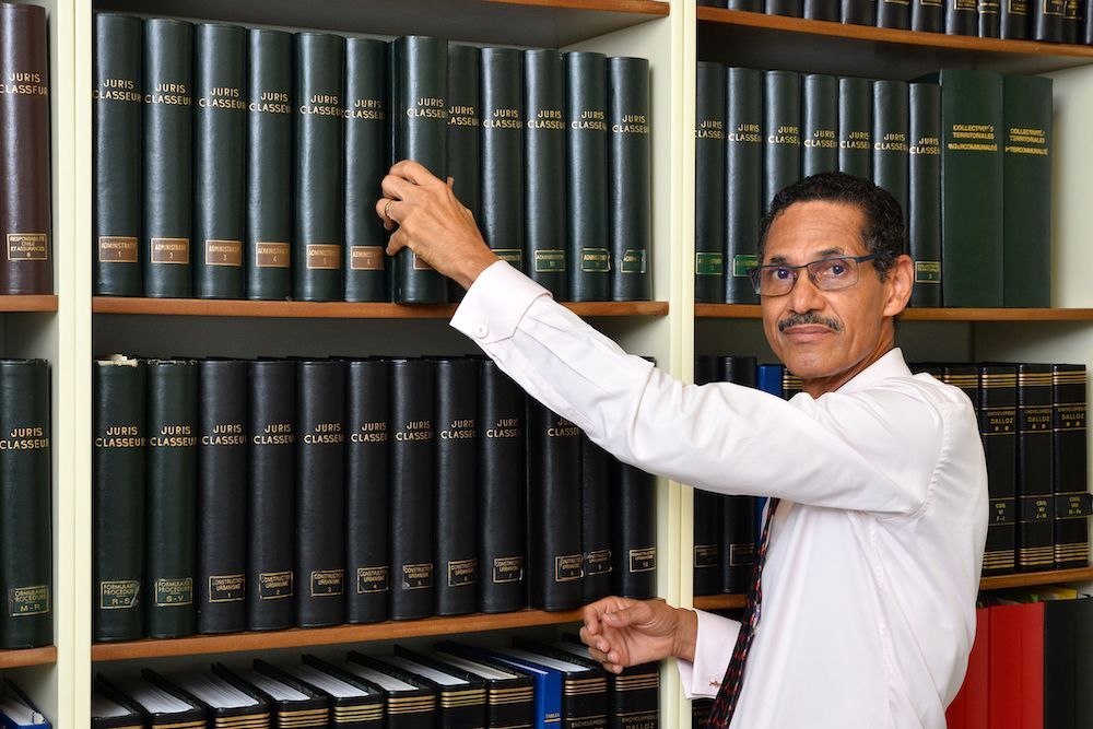 Monsieur le bâtonnier Raymond Auteville devant la bibliothèque de son cabinet