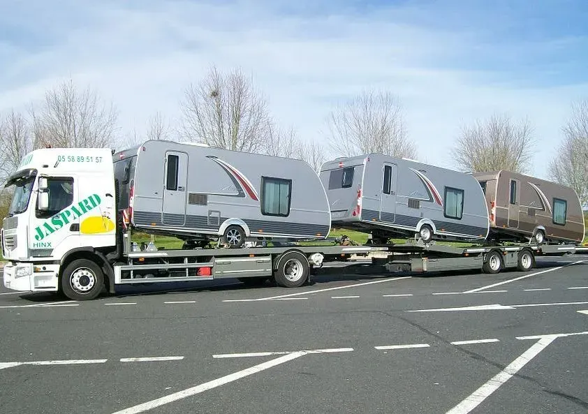 Des camping cars transportés par des camions