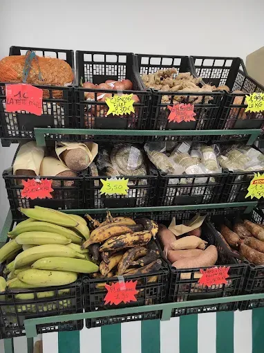 Camionnette-épicerie mobile avec étagères ouvertes remplies de nourriture. Deux comptoirs rabattables.