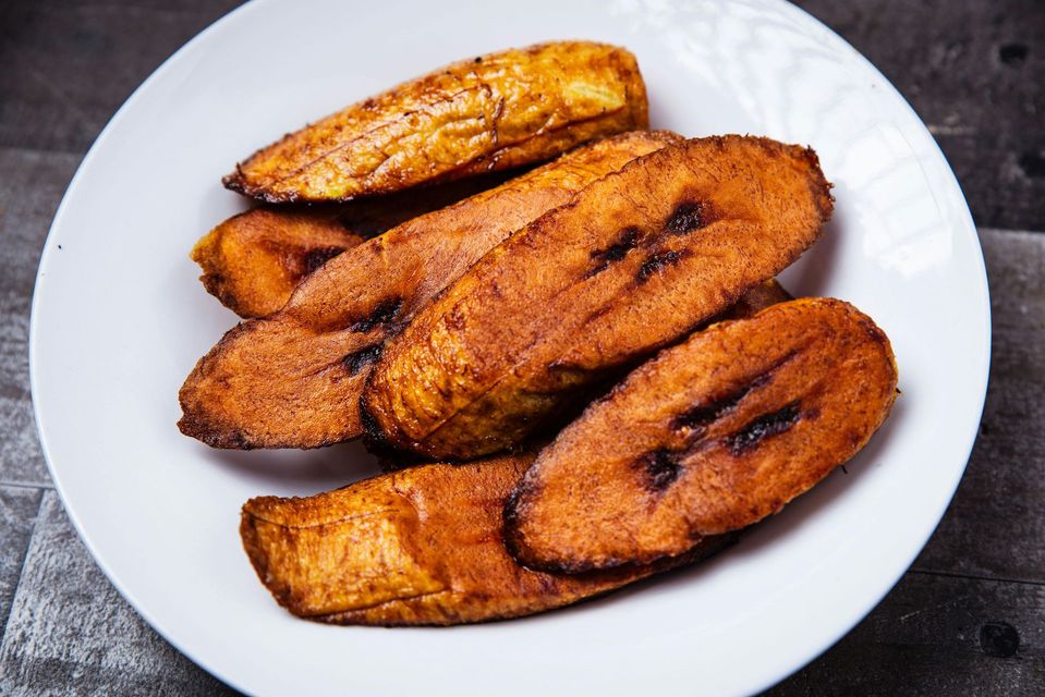 Assiette de tranches de plantain frites et dorées sur un plat blanc