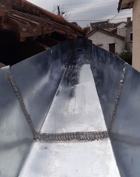 Gros plan d'une gouttière en zinc