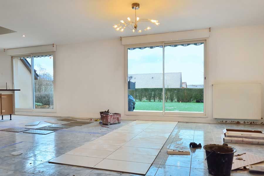 Intérieur en travaux d'une maison avec portes-fenêtres