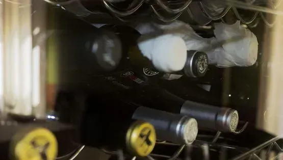 Un montón de botellas de vino están colocadas una encima de otra en un estante.