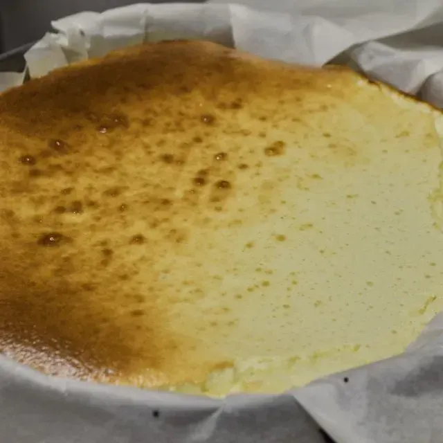 Una tarta de queso reposa sobre un trozo de papel encerado.