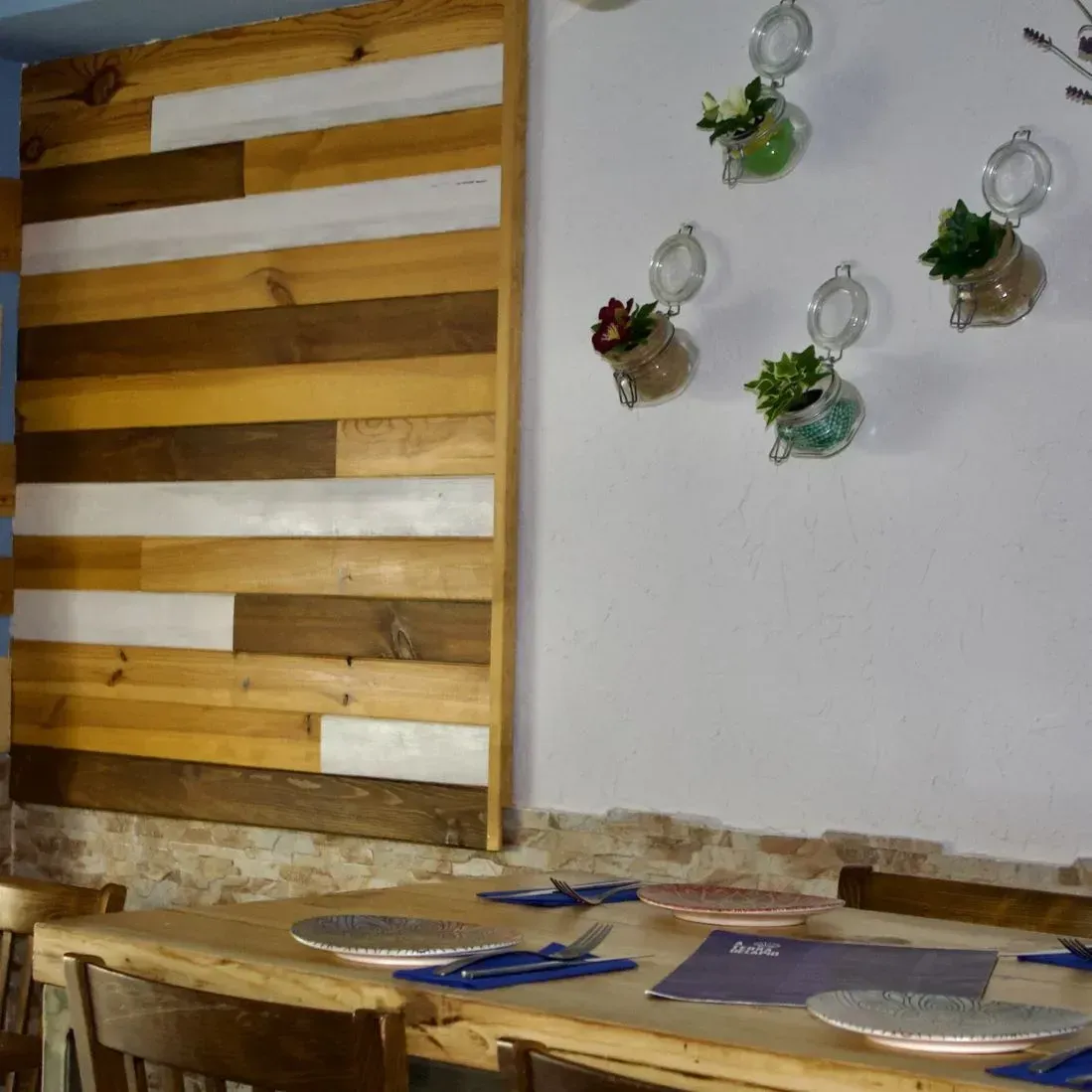 Un comedor con una pared de madera y platos en la mesa.