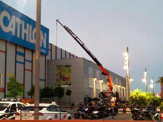 Una tienda Decathlon con una grúa delante.