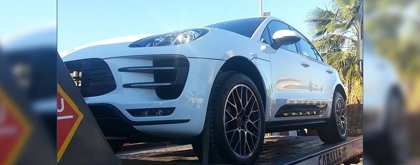 Un coche blanco está sentado encima de una grúa.