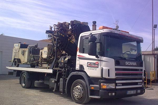 Un camión Scania blanco y negro está estacionado en un estacionamiento.