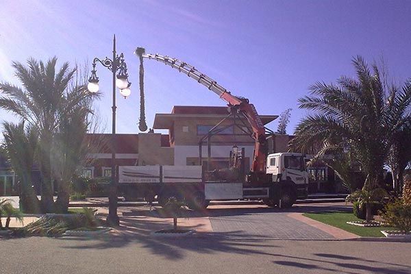 Un camión con una grúa acoplada está estacionado frente a un edificio.