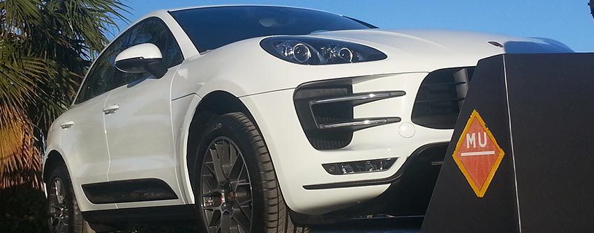 Un Porsche Macan Turbo blanco está estacionado frente a una señal de no estacionar.