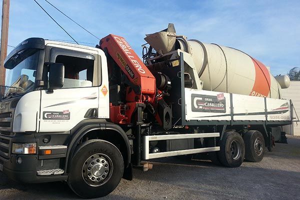 Un camión blanco con una hormigonera en la parte trasera.