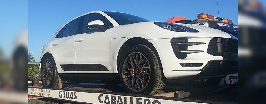 Un coche blanco está sentado encima de una grúa.