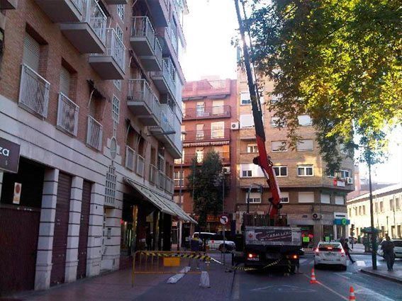 Un camión circula por una calle frente a un edificio.
