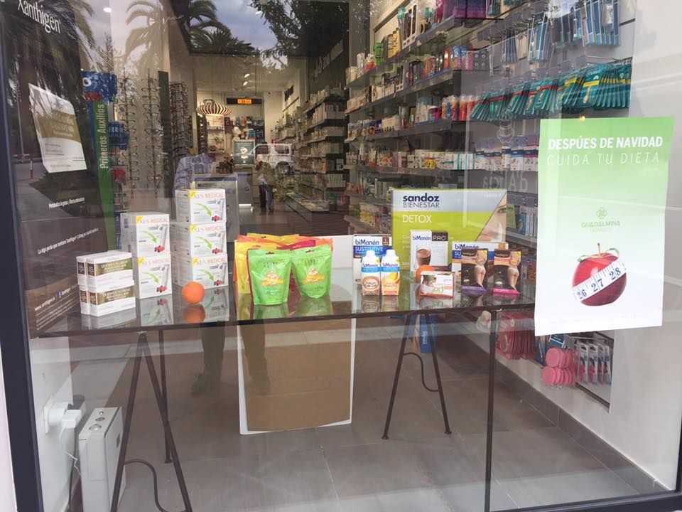 Un escaparate de farmacia con una mesa delante llena de muchos productos.