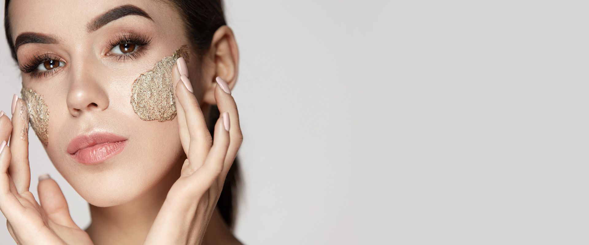 Una mujer se está aplicando un exfoliante en la cara.