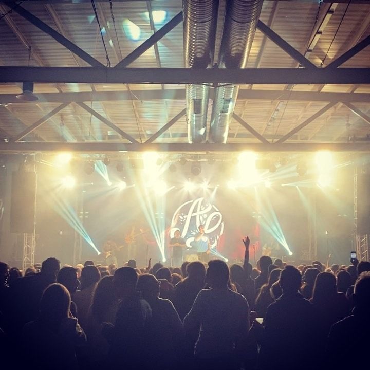 Una multitud de personas viendo un concierto con un logo que dice ao.