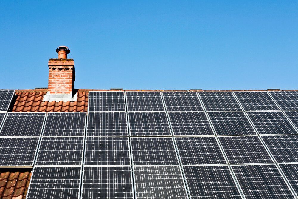 Hay muchos paneles solares en el tejado de una casa.