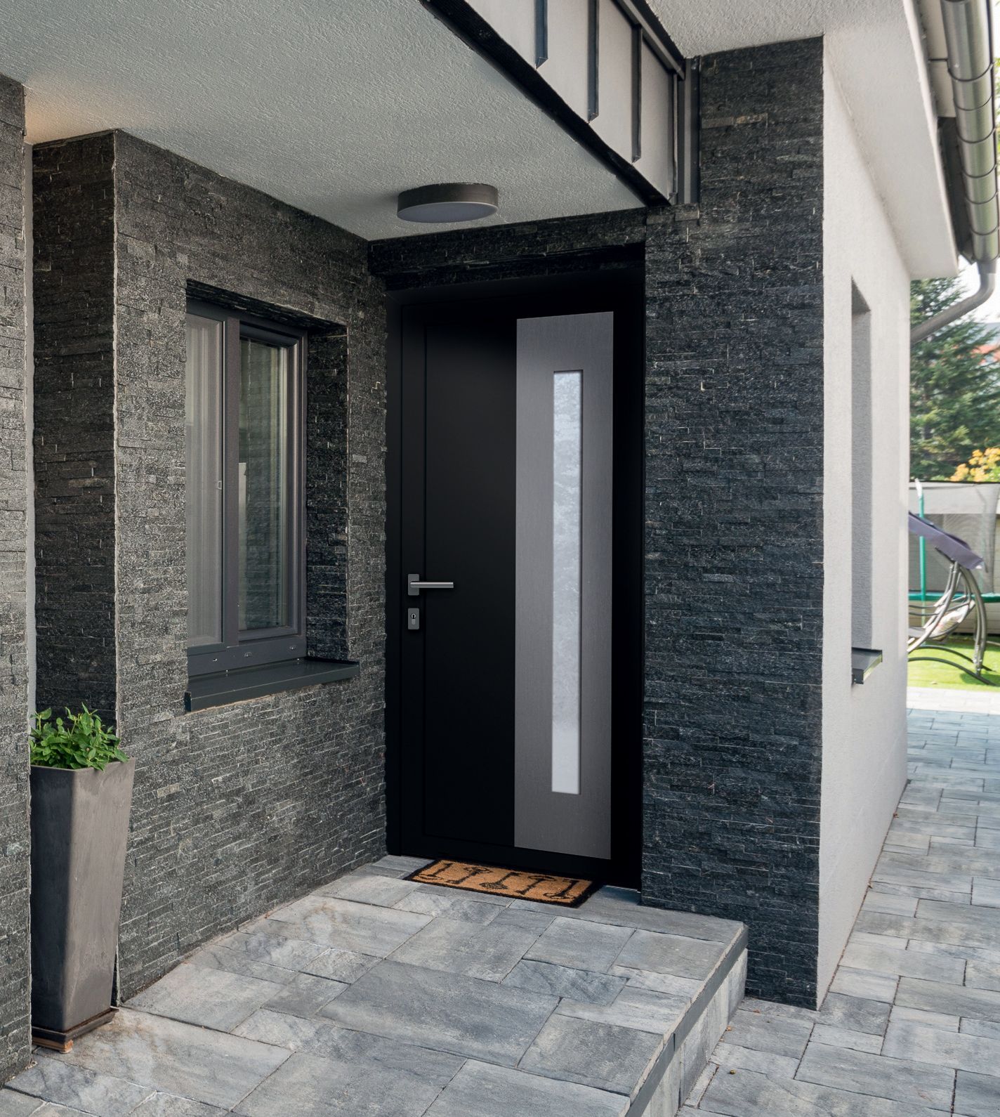 Porte d'entrée noire avec mur de parement