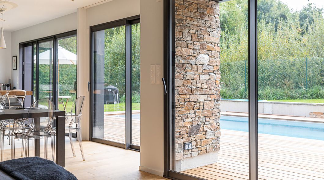 Baie vitrée avec vue sur un mur en pierre de parement