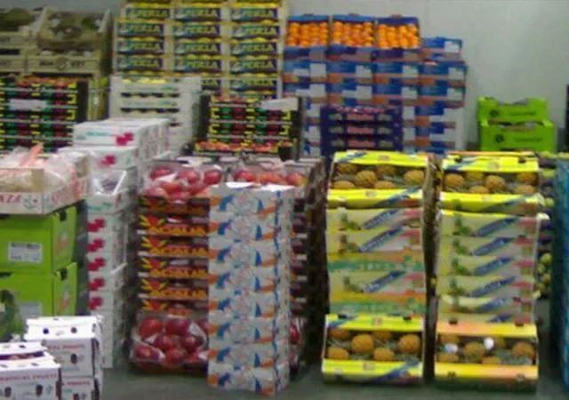 Las cajas de fruta se apilan una encima de otra en una tienda