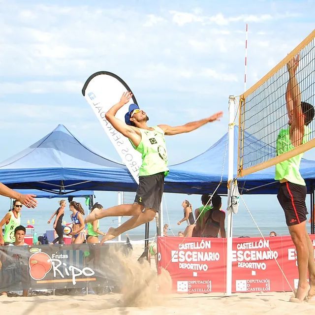 Dos hombres juegan voleibol frente a una pancarta que dice ripo