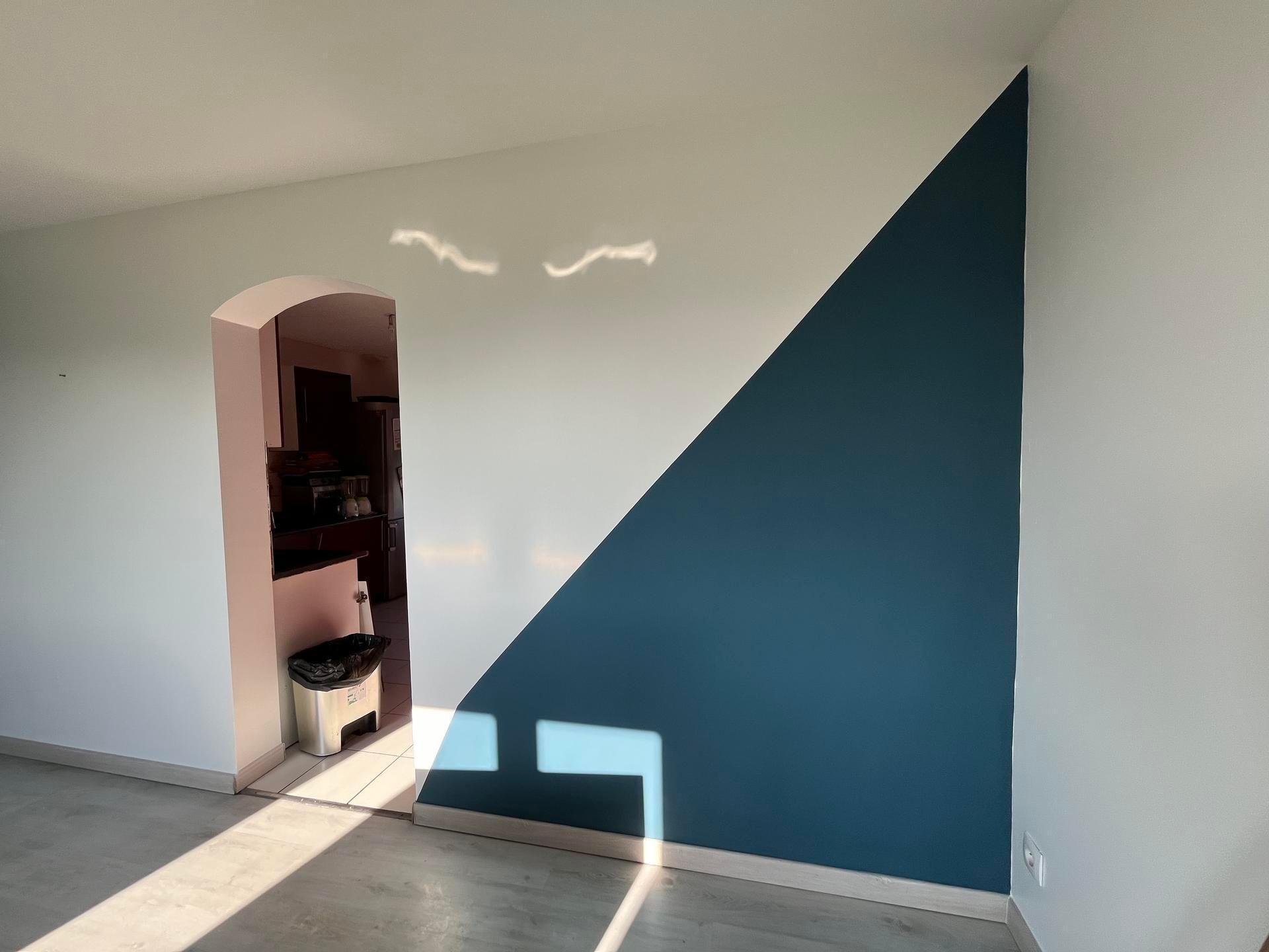 Pièce intérieure avec un mur aux accents turquoise et des murs blancs.