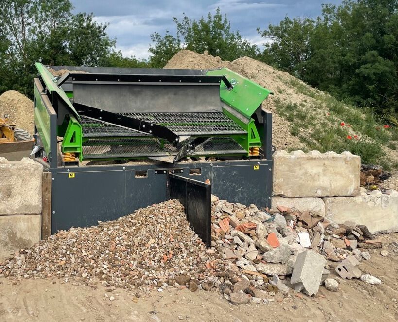 Machine de criblage industrielle séparant les gravats sur un chantier de construction.