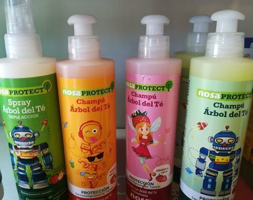 Cuatro botellas de productos nosa protect están alineadas sobre una mesa