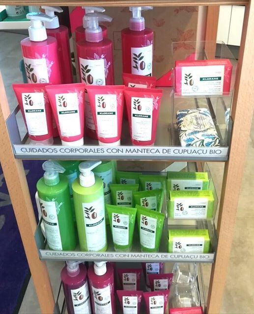 A shelf full of bottles and tubes with a sign that says cuidados corporales con manteca de cupuacu bio