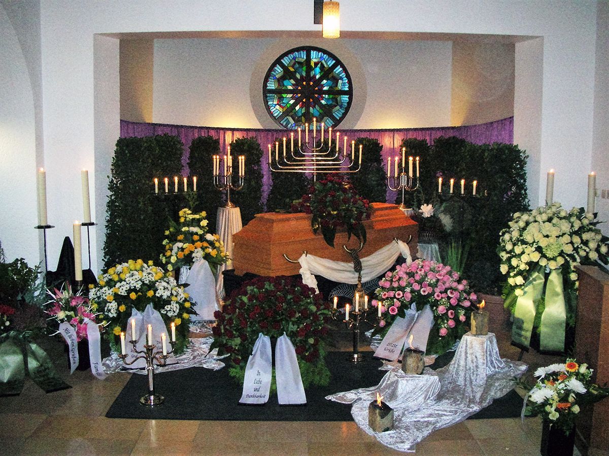 Eine Kirche mit Kerzen und Blumen und einem Buntglasfenster