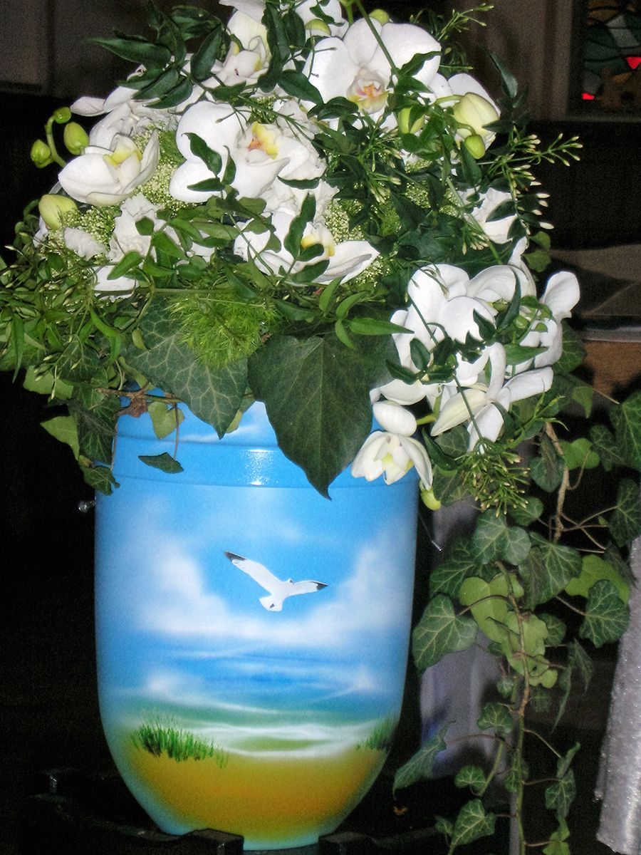 Eine blaue Vase mit Blumen und einem Vogel darauf