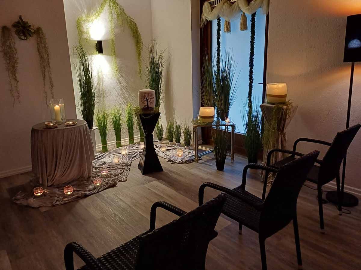 Ein Raum mit Stühlen und einem Tisch mit Kerzen darauf