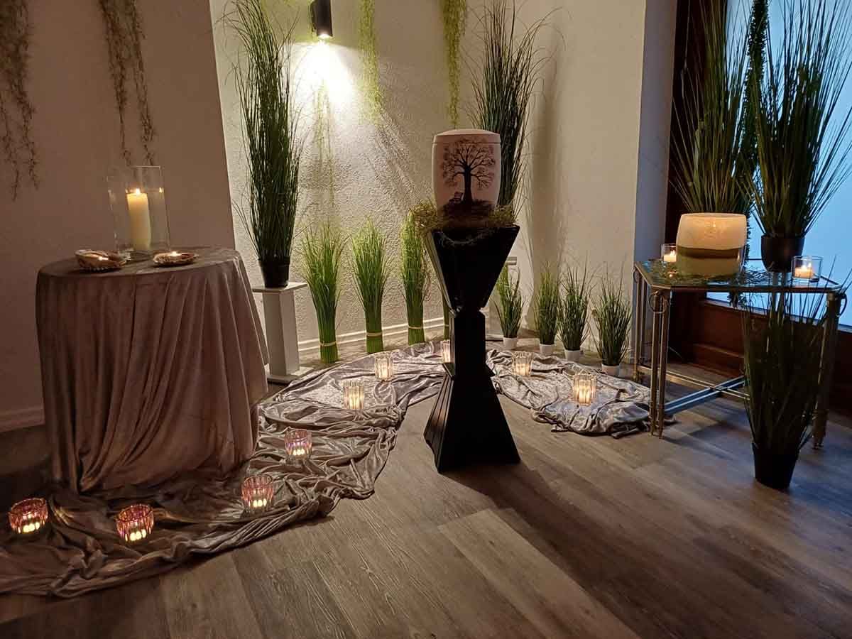 Ein Raum mit einem Tisch, Kerzen und Topfpflanzen.