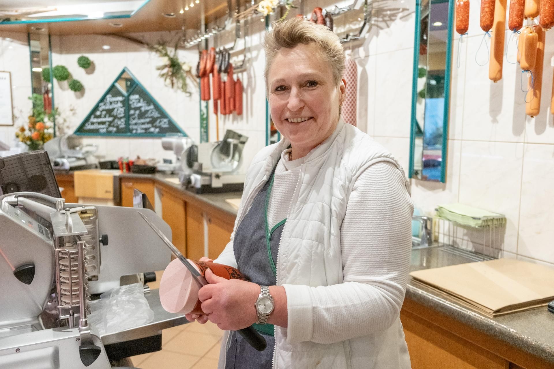 Metzgerei-Team bei der Arbeit an der Fleischtheke mit frischen Wurst- und Fleischwaren