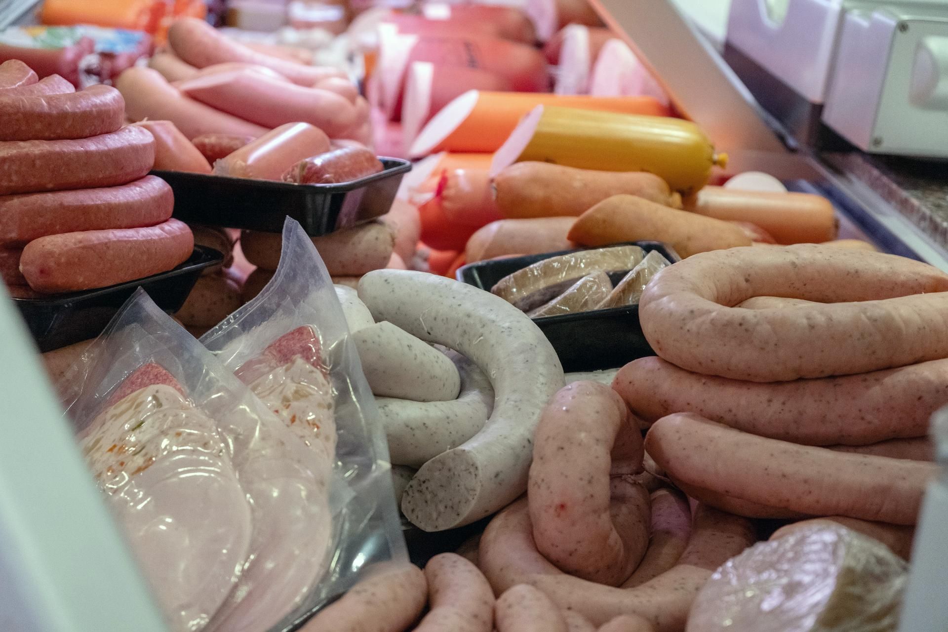 Verschiedene Brühwürste und Spezialitäten frisch präsentiert in der Metzgerei-Theke