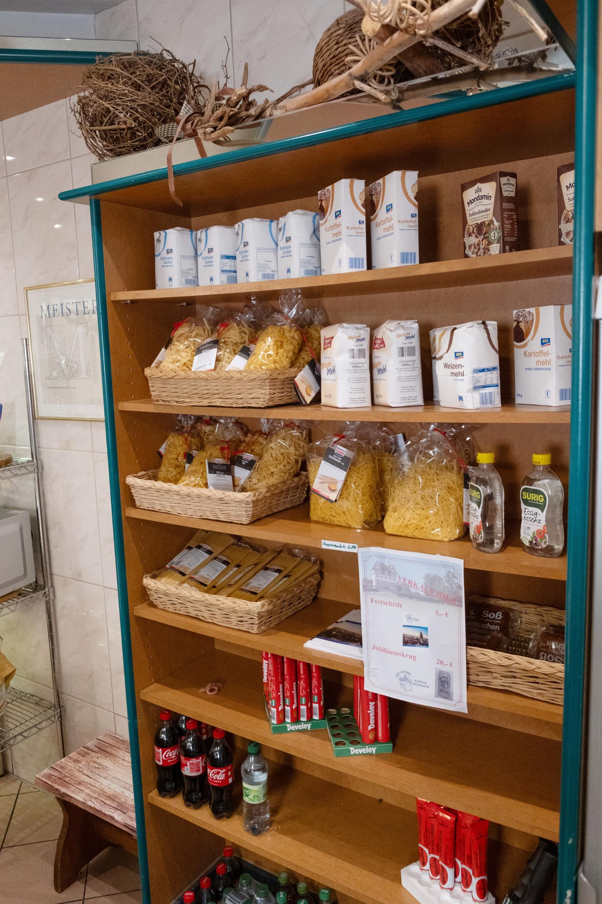 Feinkostregal mit Gewürzen, Gläsern und regionalen Spezialitäten