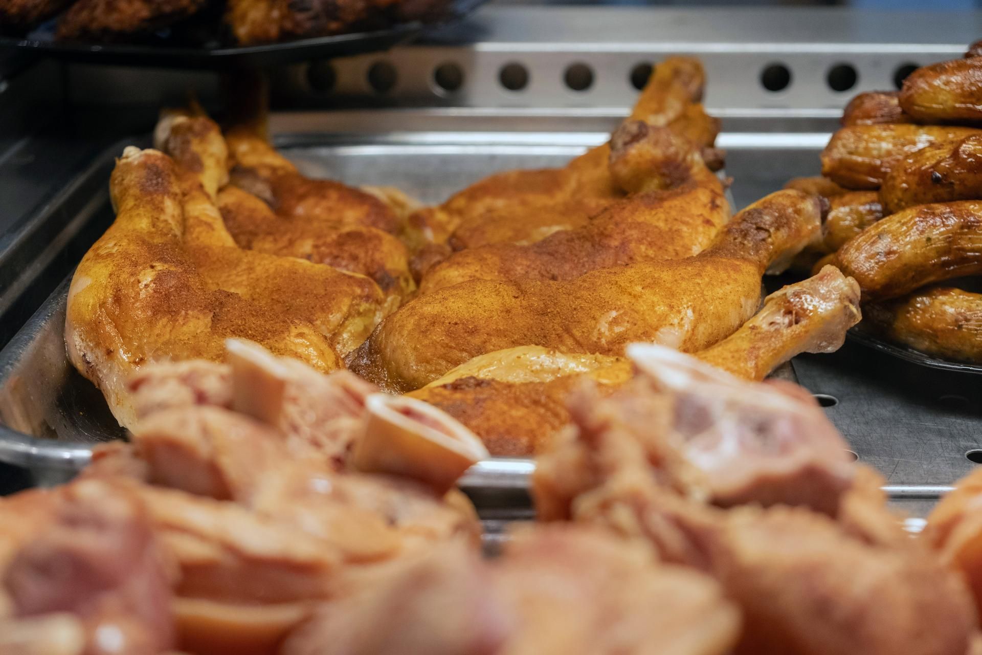 Goldbraune Grillhähnchen und warme Spezialitäten aus der Heißtheke der Metzgerei