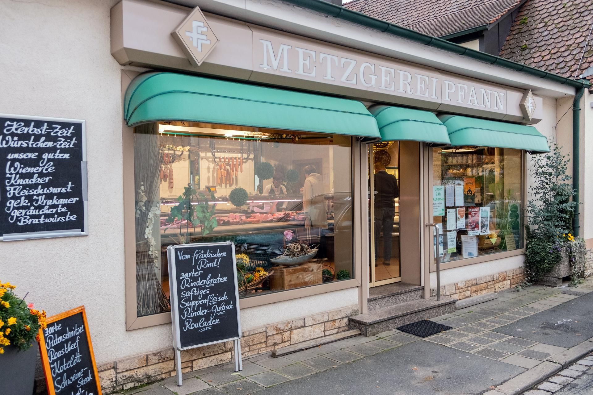 Außenansicht der Metzgerei Pfann mit Schaufenster, Markise und regionalem Angebot.