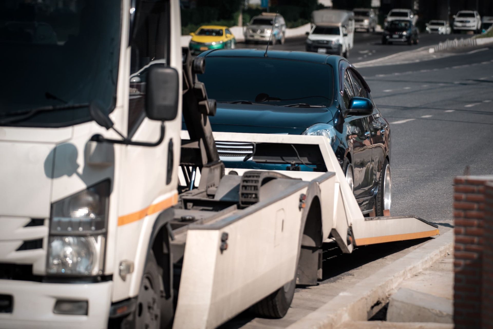 Una grúa está remolcando un automóvil al costado de la carretera.