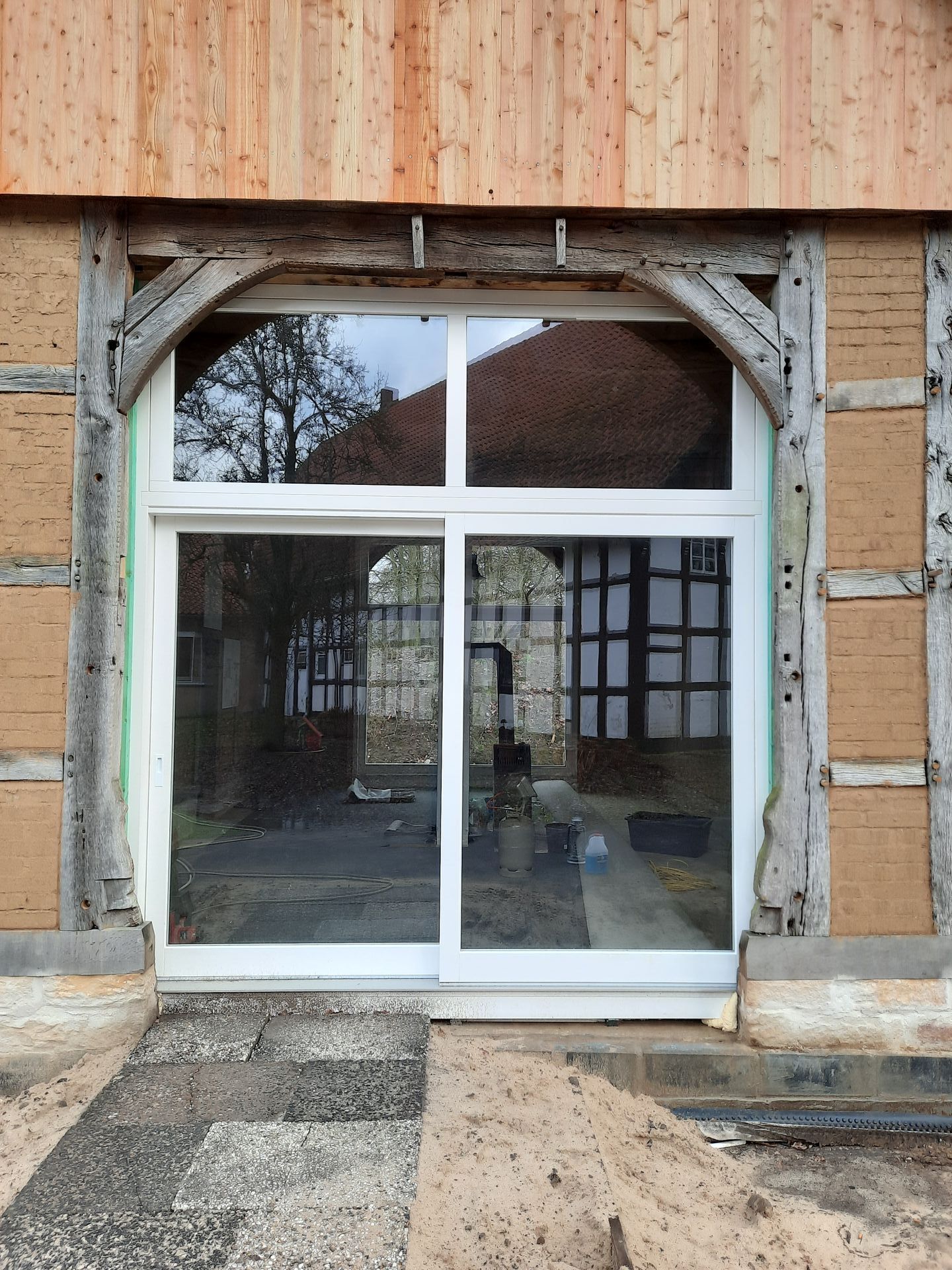 Ein Gebäude mit einer Glasschiebetür und einem Holzrahmen