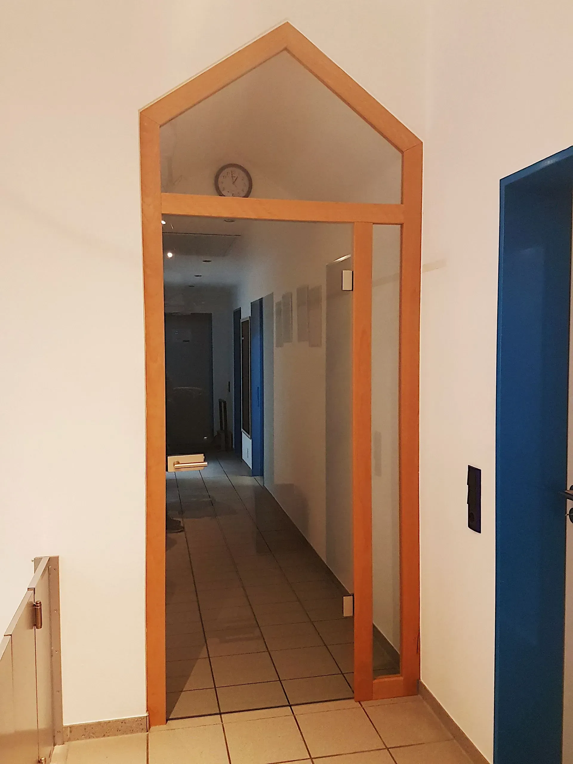 Ein Flur mit einer blauen Tür und einer Holztür