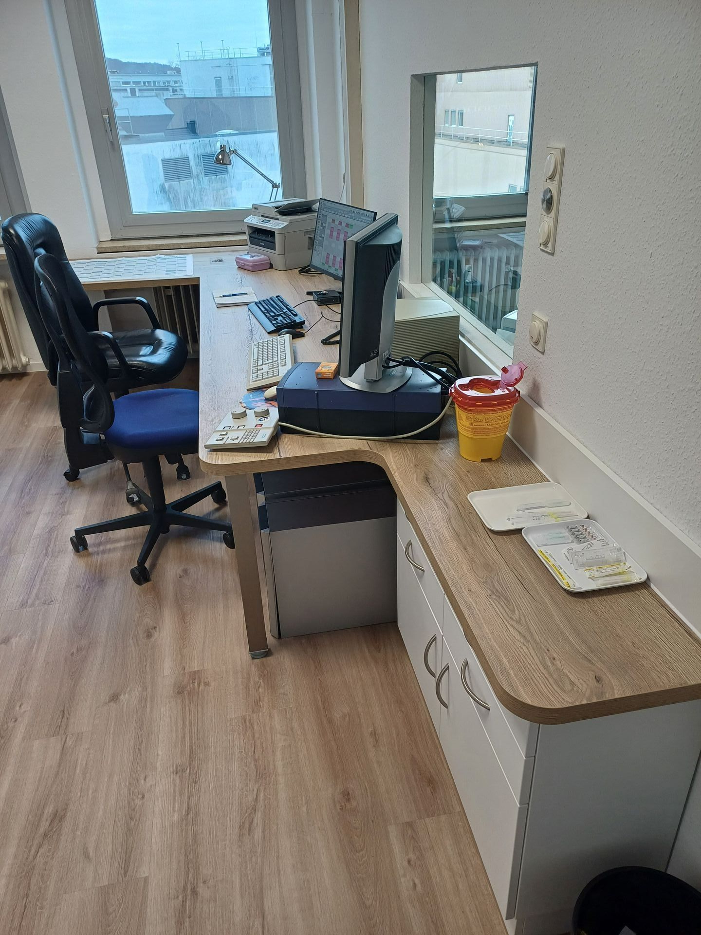 Ein Schreibtisch mit einem Computer und einem Stuhl in einem Zimmer.